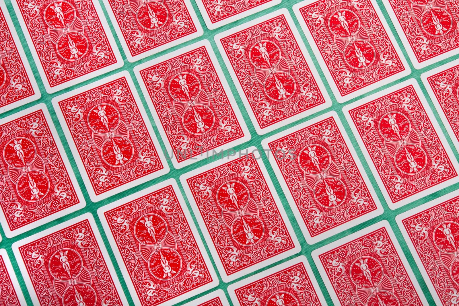 Close up view of a bunch of flipped playing cards spread on a green cloth table.