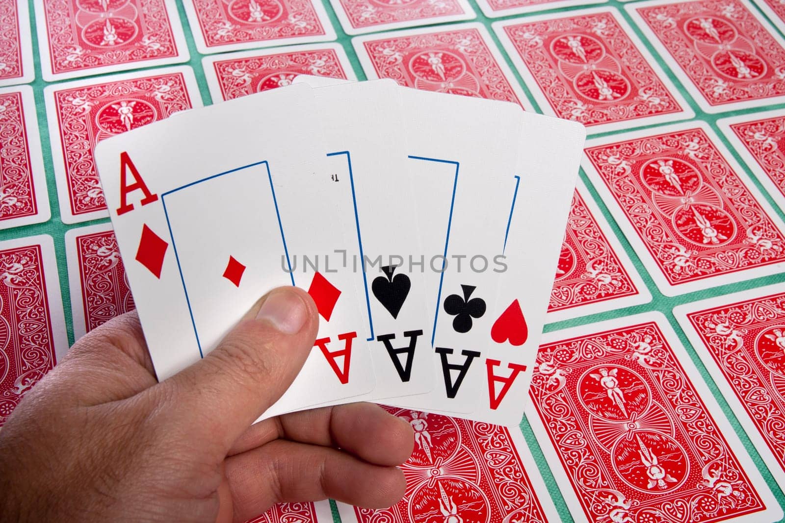 Close up view of a bunch of flipped playing cards spread on a green cloth table.
