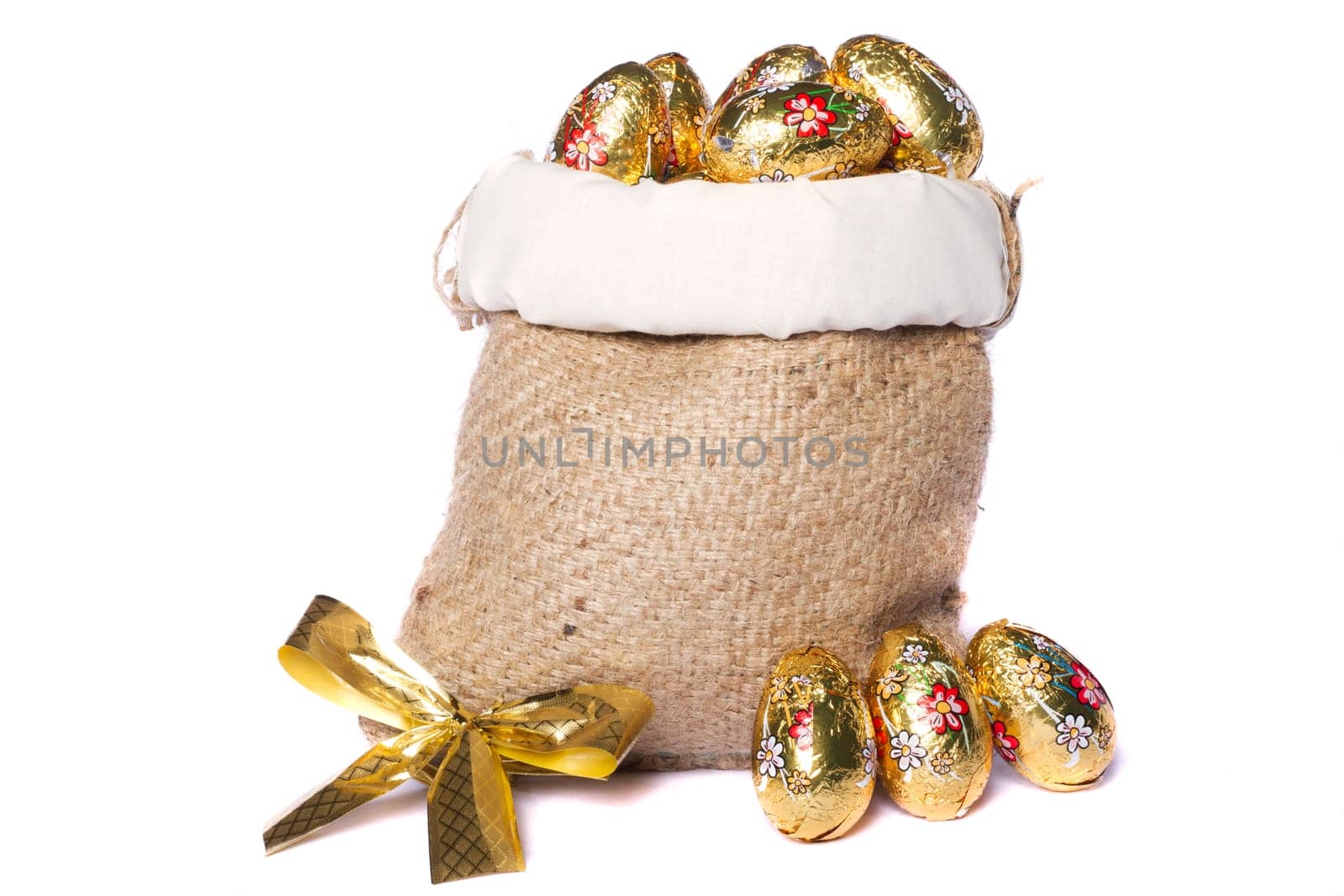 Close up view of sweet golden eggs inside a sack isolated on a white background.