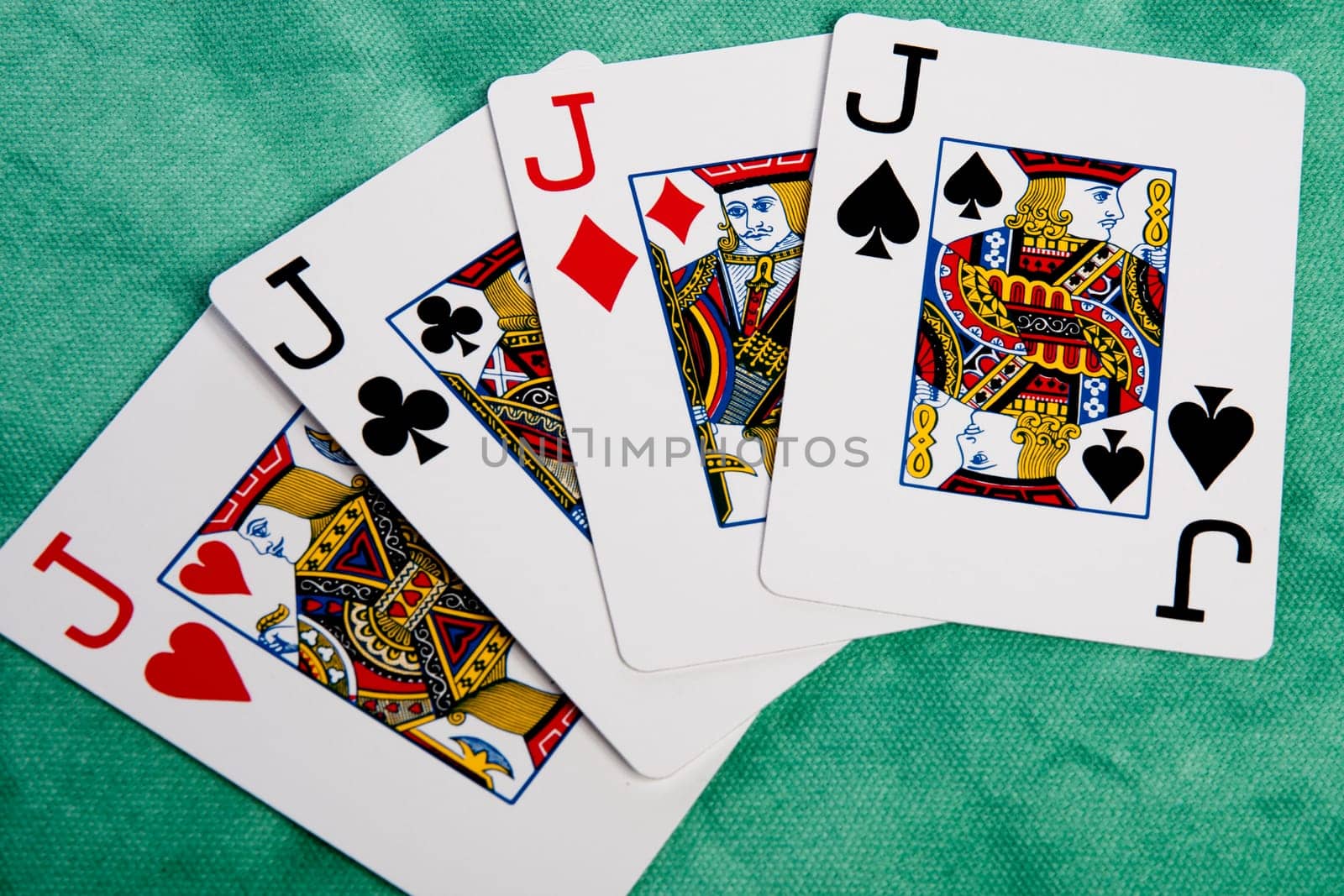 Close up view of a set of four jacks spread on a green cloth table.