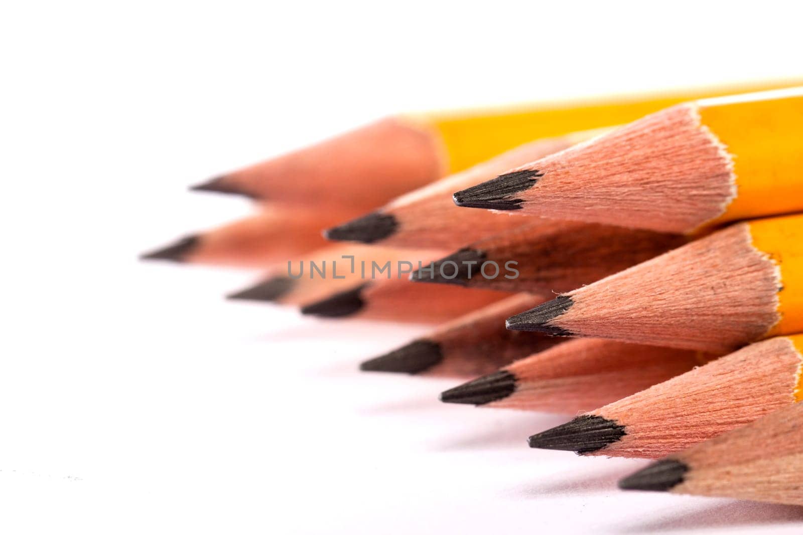 Close up view of a bunch of yellow pencils isolated on a white background.
