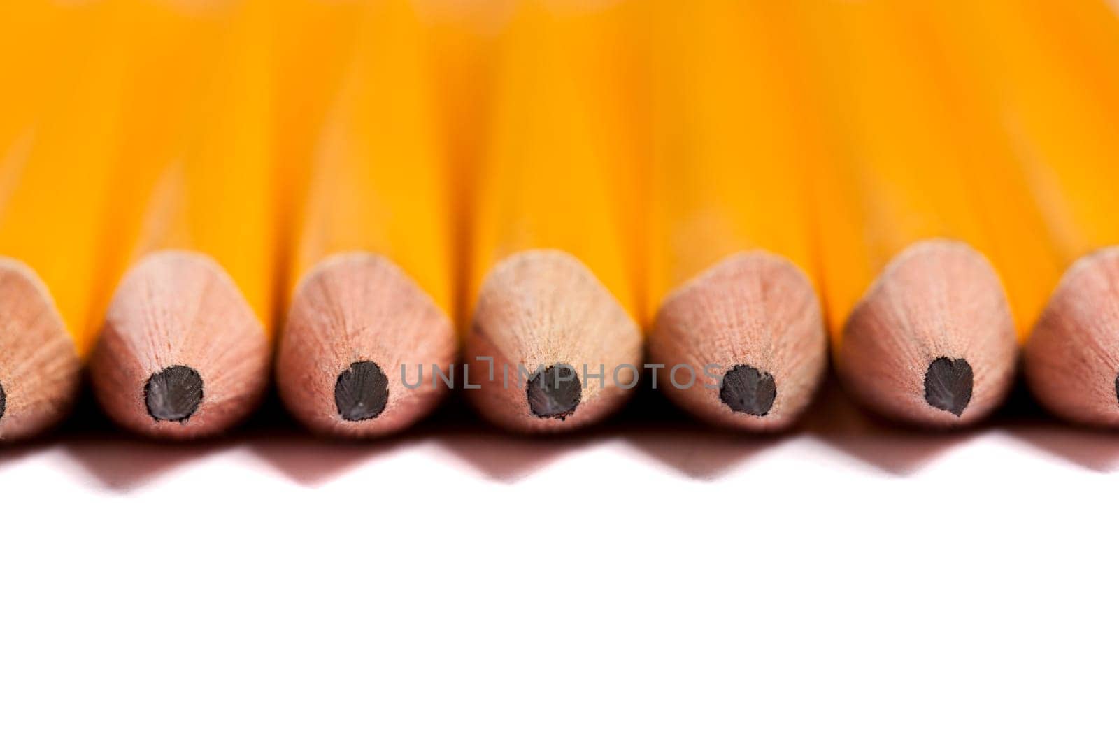 Close up view of a bunch of yellow pencils isolated on a white background.