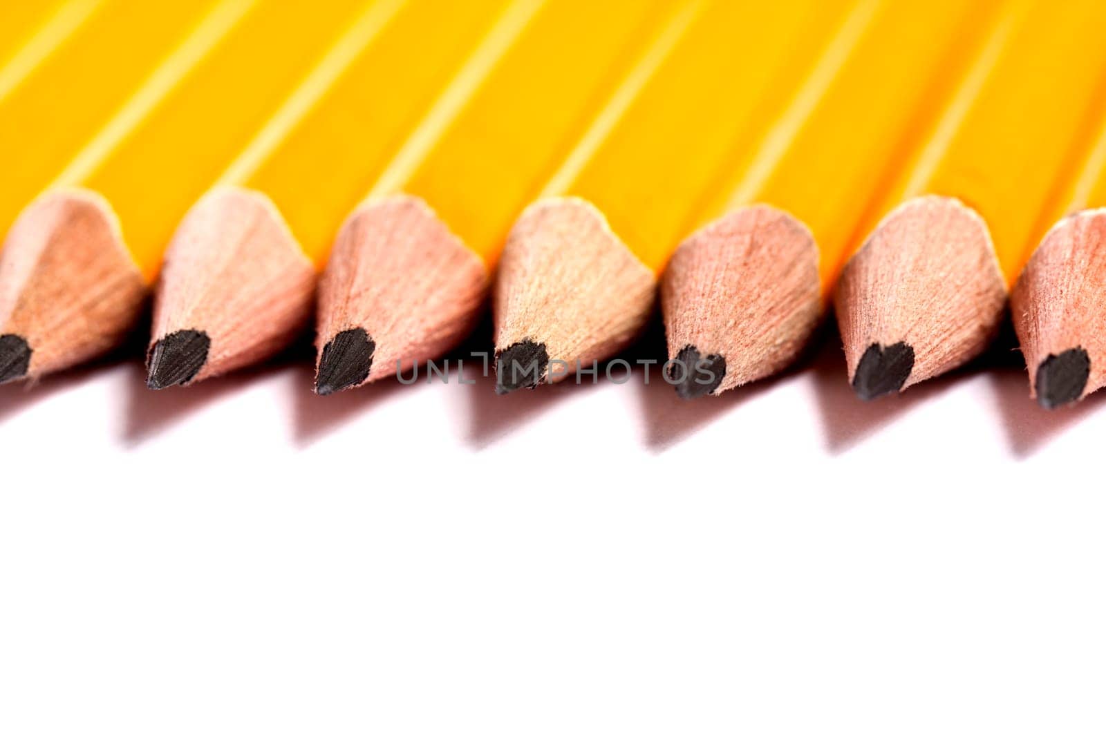 Close up view of a bunch of yellow pencils isolated on a white background.