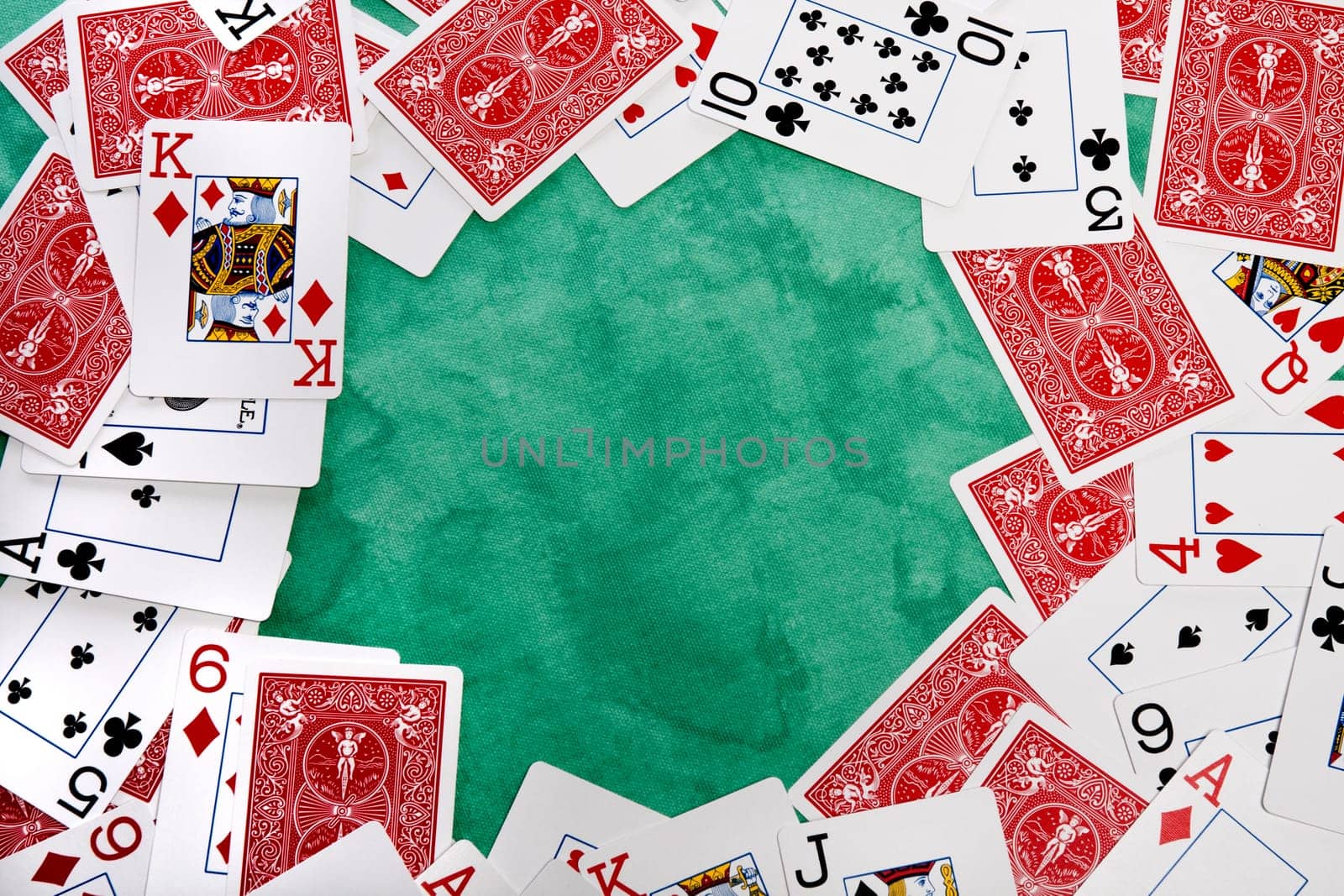 Close up view of a bunch cards spread on a green cloth table.