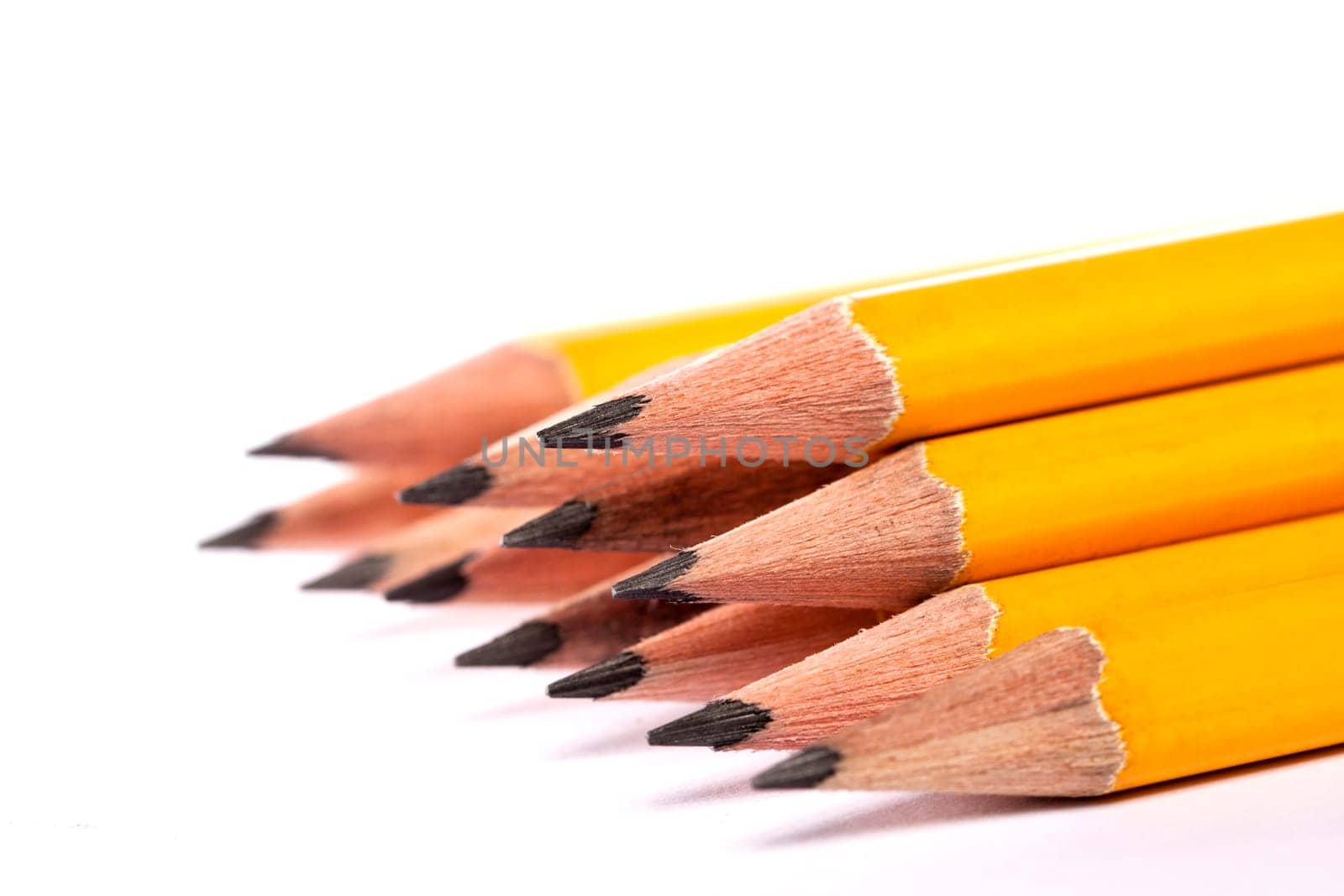 Close up view of a bunch of yellow pencils isolated on a white background.