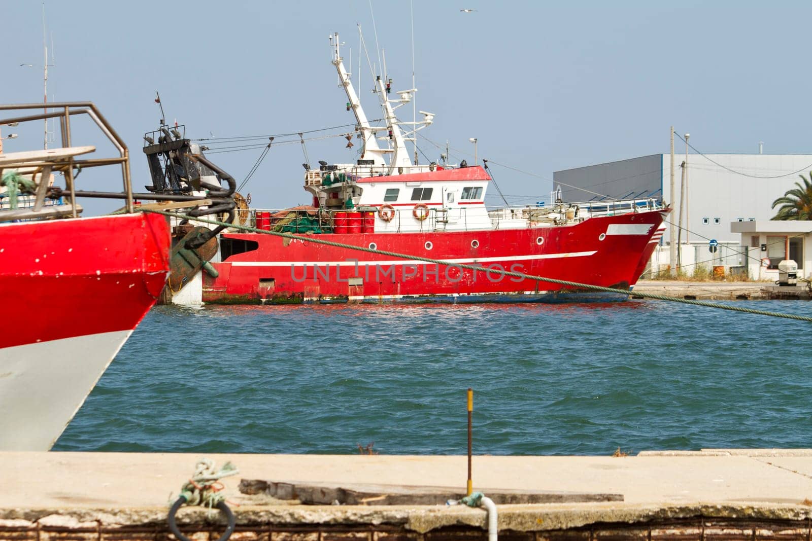 View of a red fishing boat anchored on the docks.