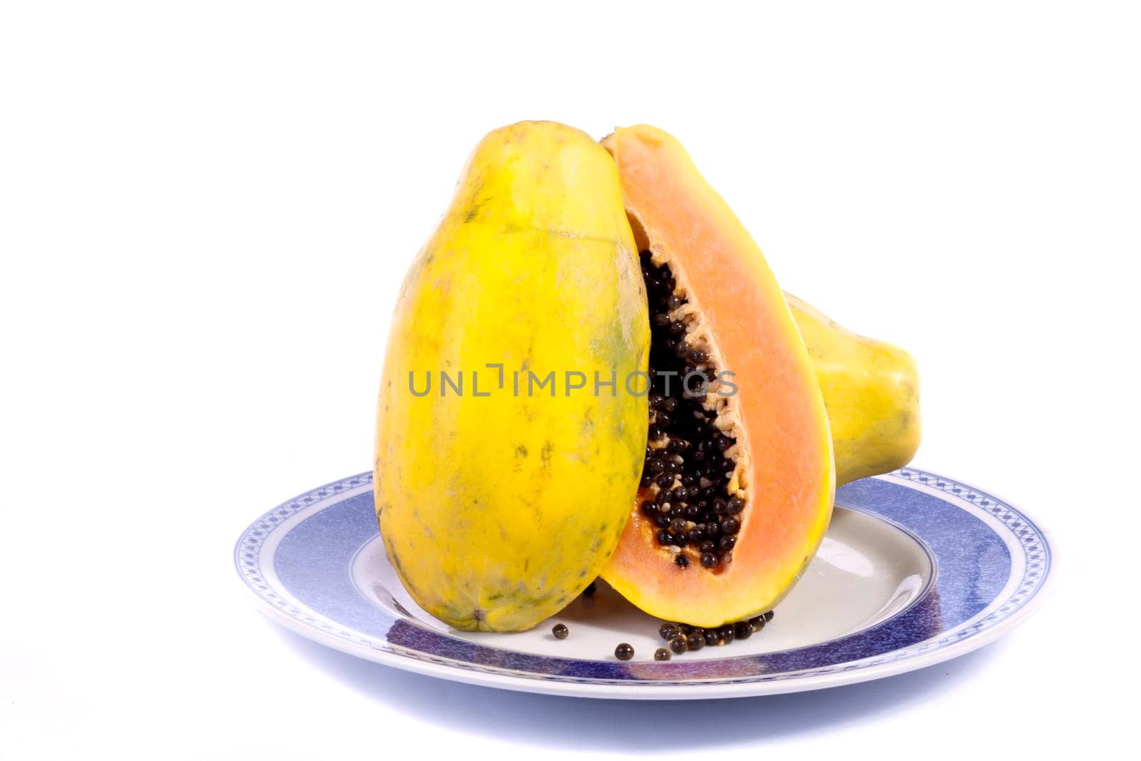 Close up view of papaya fruit sliced presented on a dish.