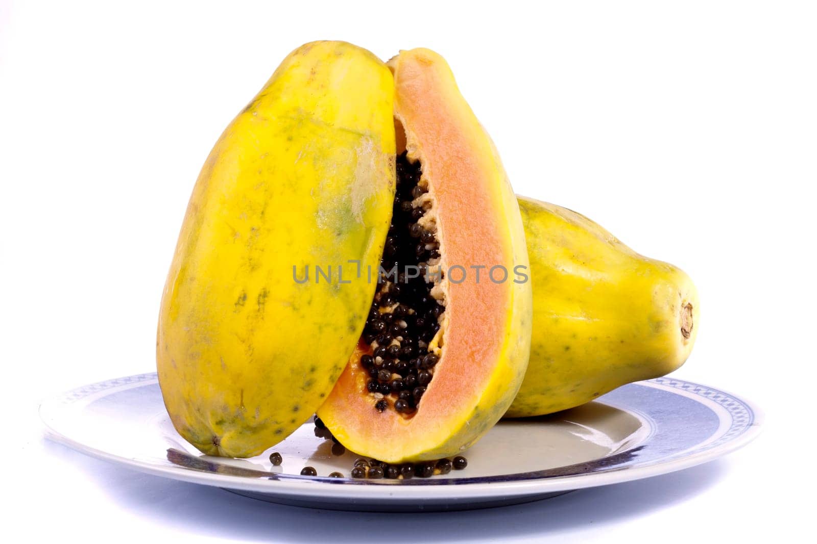 Close up view of papaya fruit sliced presented on a dish.
