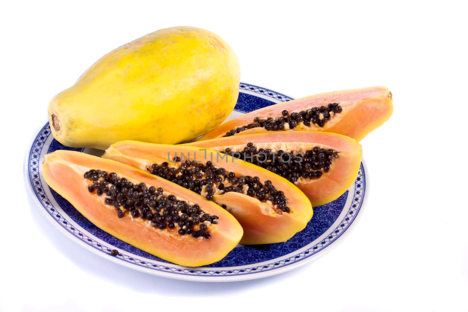 Close up view of papaya fruit sliced presented on a dish.
