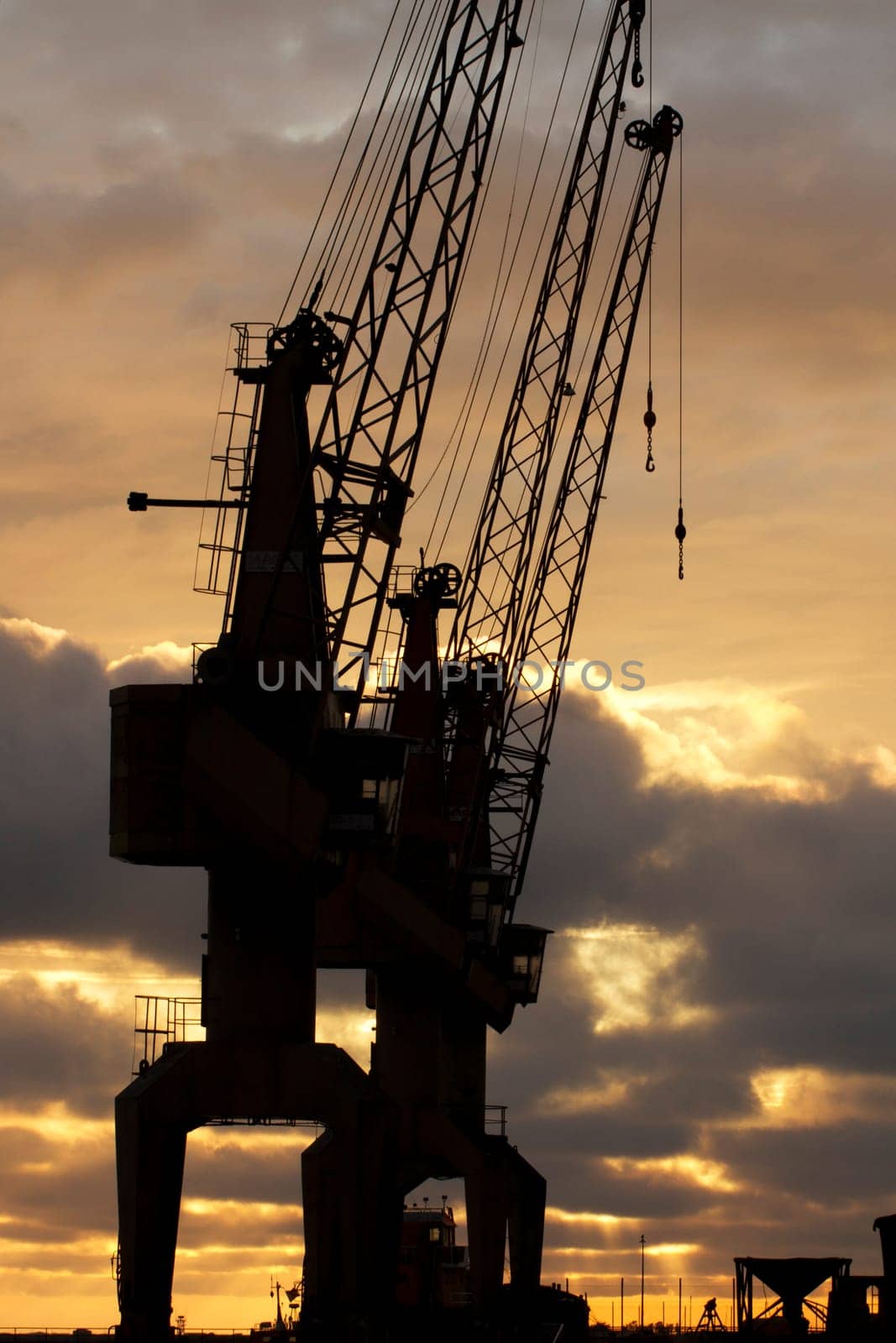 View of two harbor silhouettes cranes at sunset.