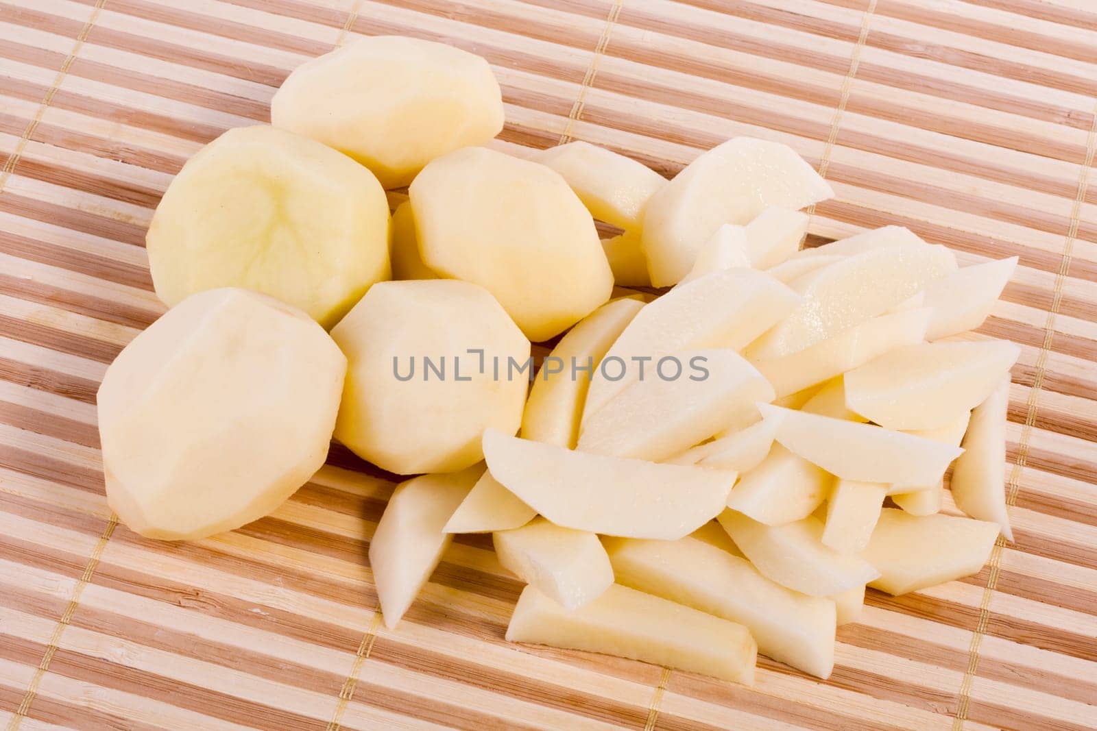 Close up view of some sliced potatoes isolated on bamboo background.