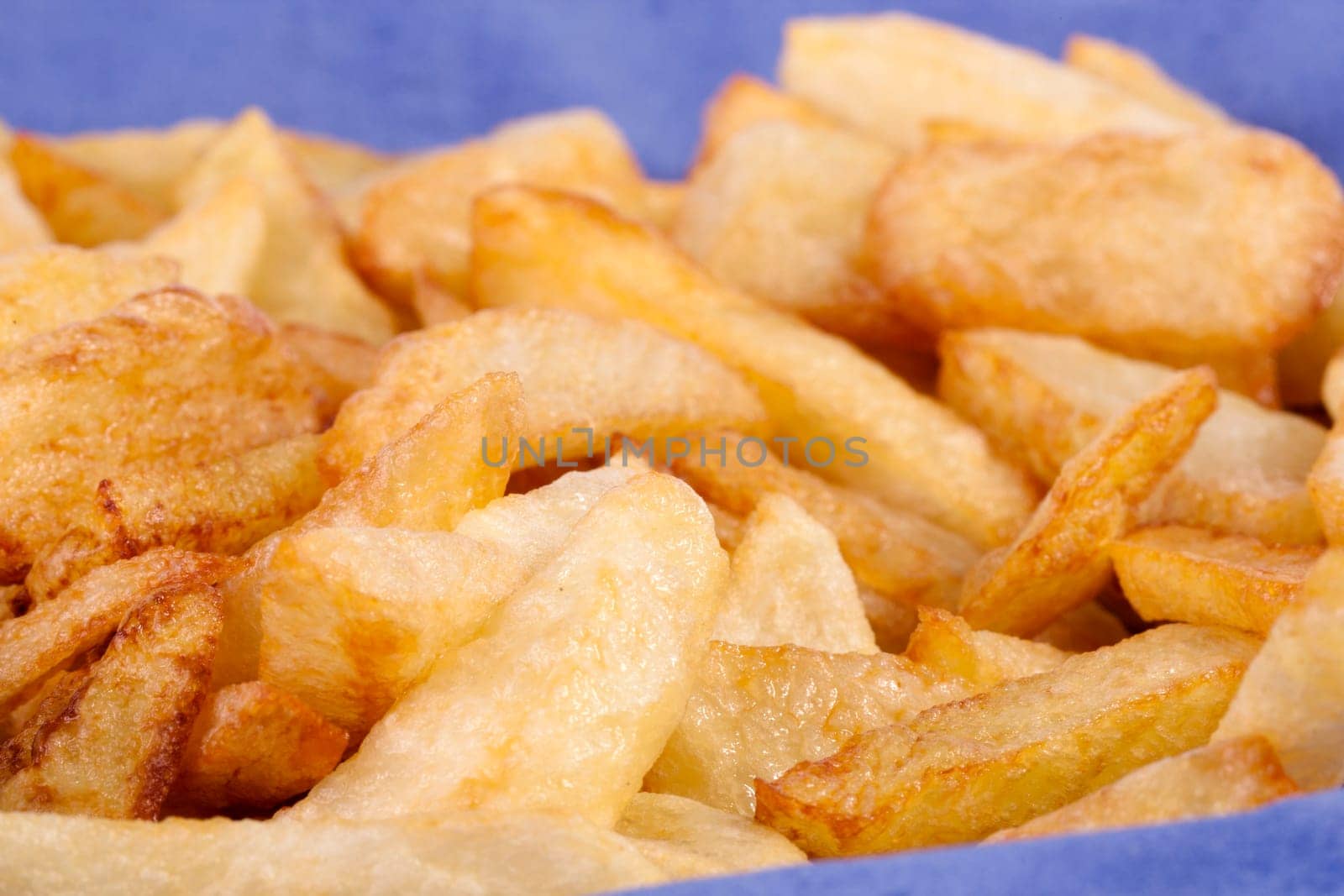Close up view of a bunch of fried potatoes in slices.