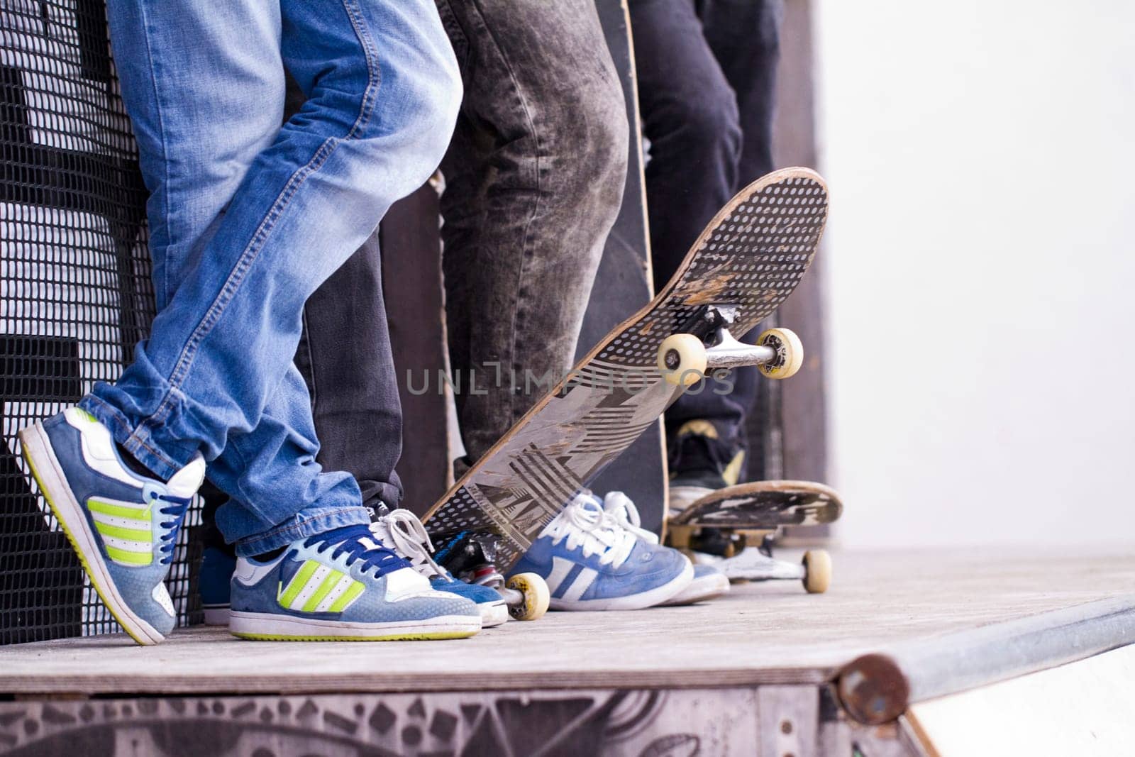 View of a bunch of skaters with skate boards on a pipe.