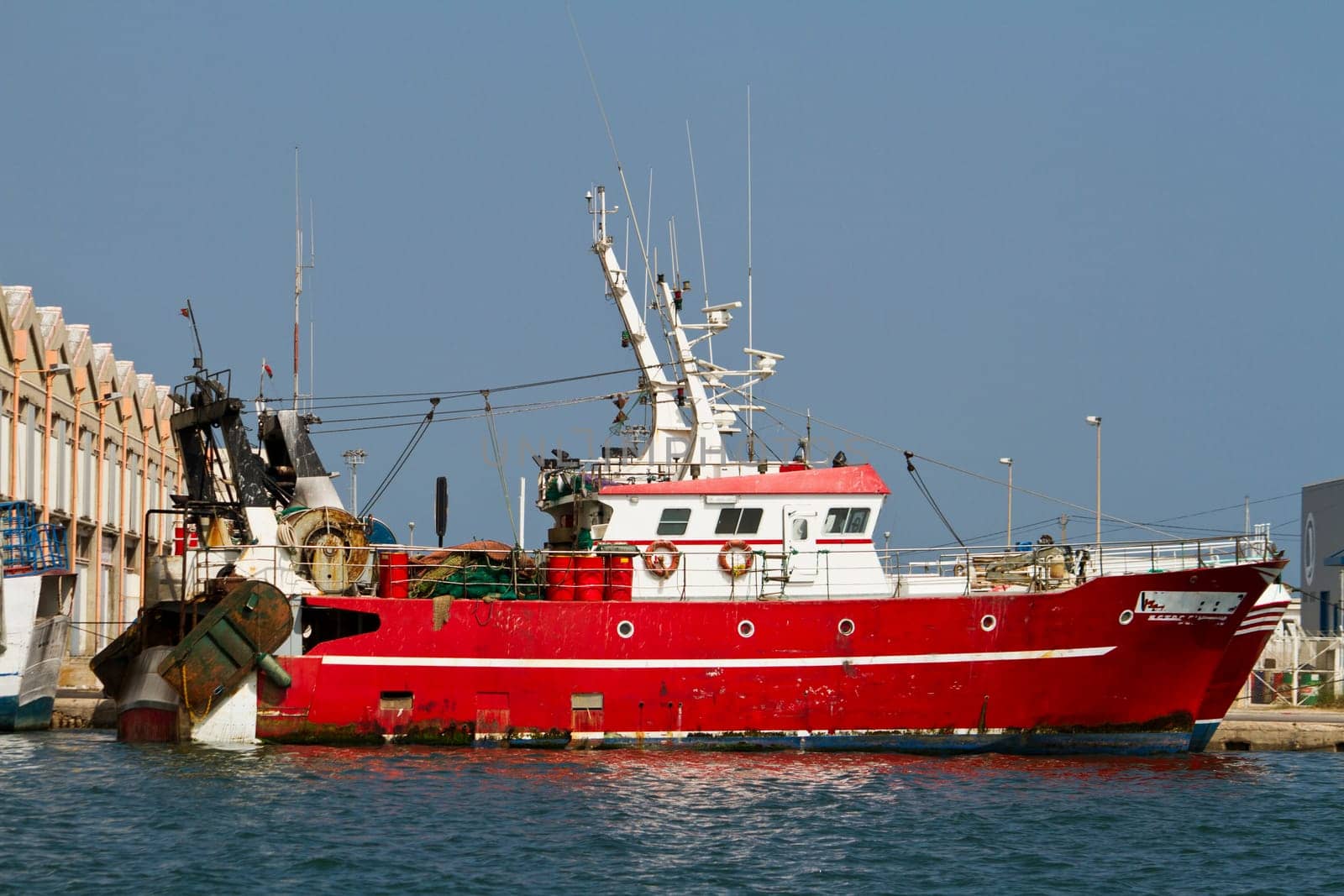 View of a red fishing boat anchored on the docks.