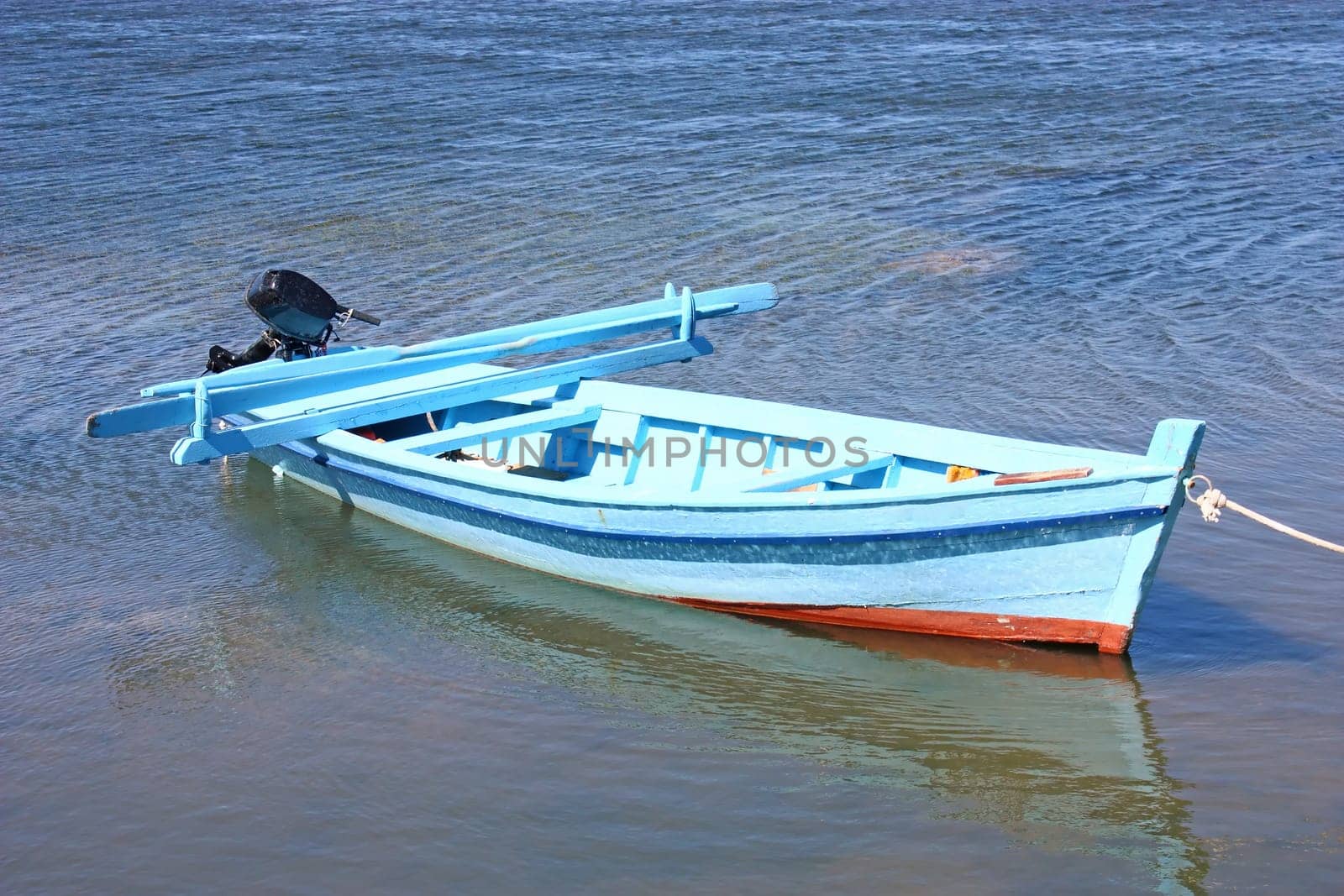 Lonely wooden fishing rowboat on the sea