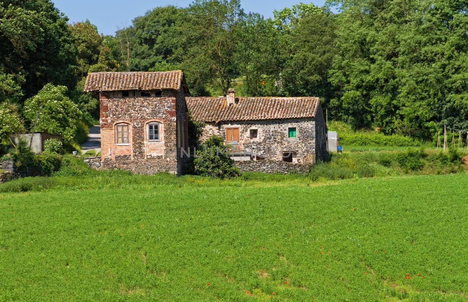Typical Catalan countryside, rural grass with your mower, straw waltz and the church, surrounded by mountains
