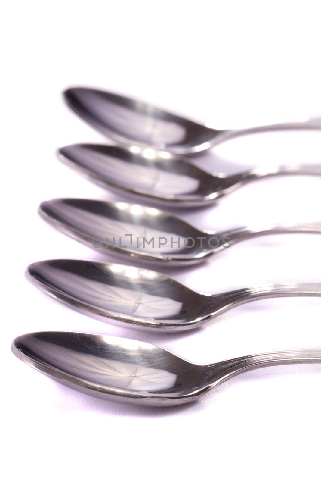 Close up view detail of some spoons isolated on a white background.