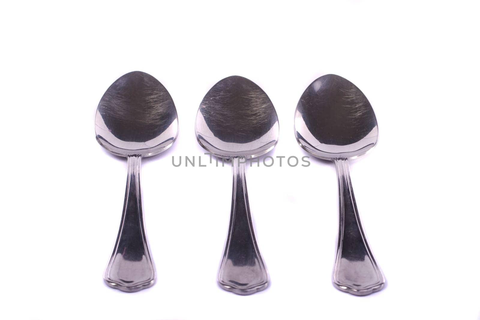 Close up view detail of some spoons isolated on a white background.