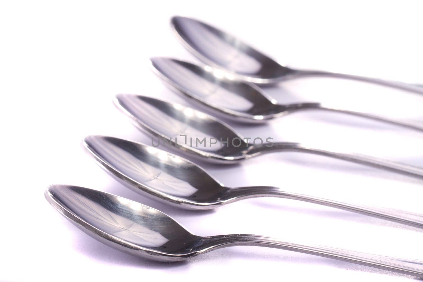 Close up view detail of some spoons isolated on a white background.
