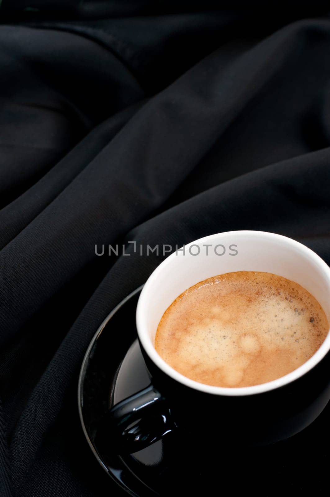 Cup of Espresso Coffee on Black Silky Drapery