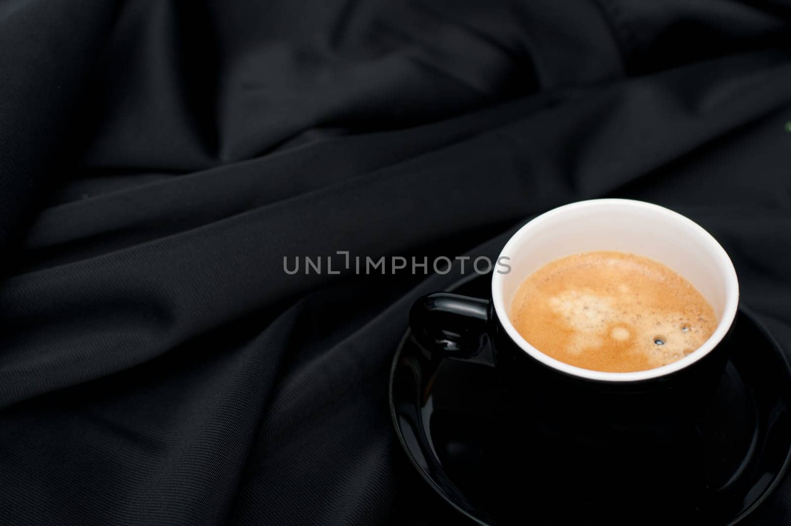Cup of Espresso Coffee on Black Silky Drapery
