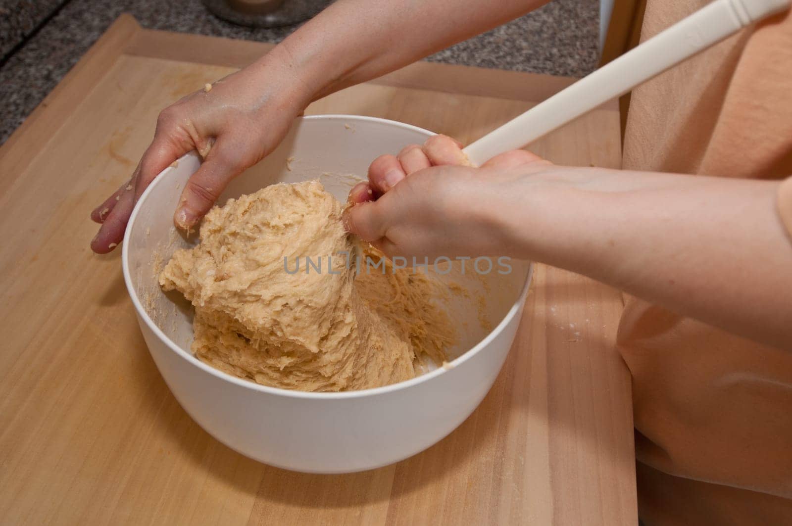 Yeast dough is stirred with a mixing spoon