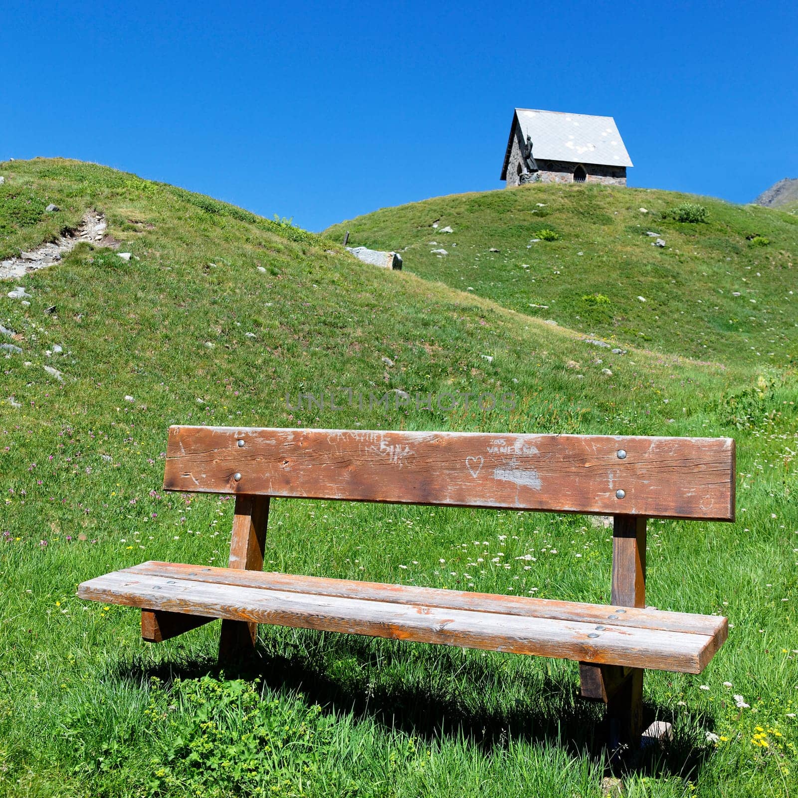 chapel and bench in alpine mountain in summer