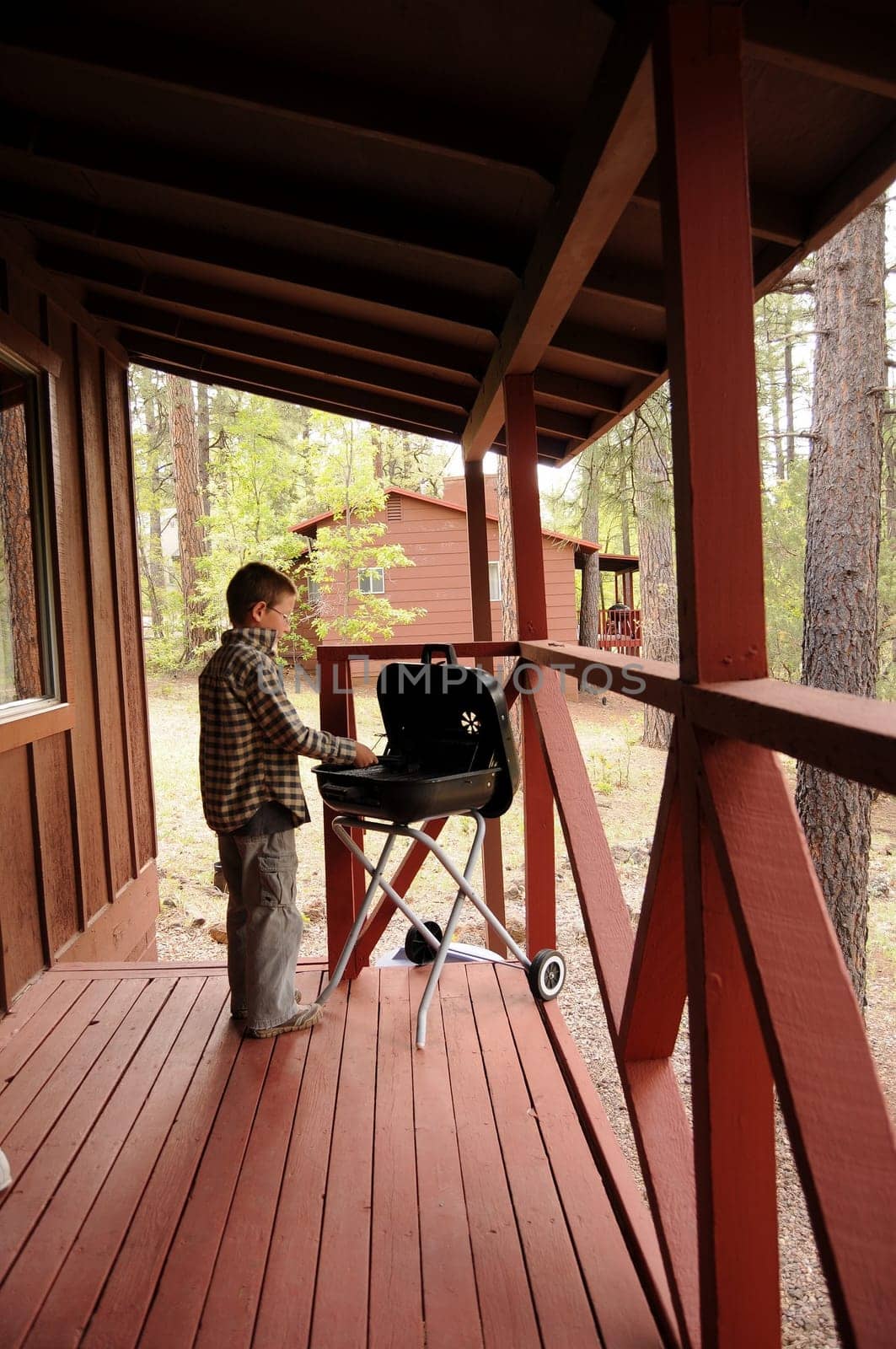 Boy on porch cleaning a barbecue