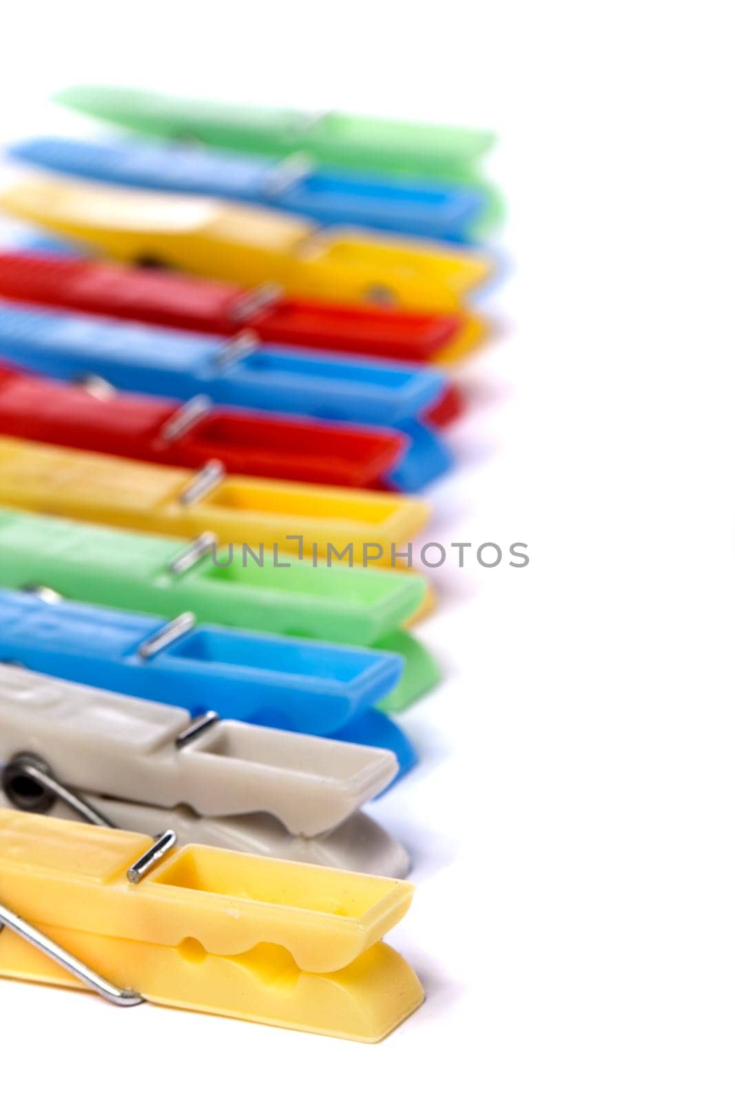 Close up view of some colorful cloth pegs isolated on a white background.
