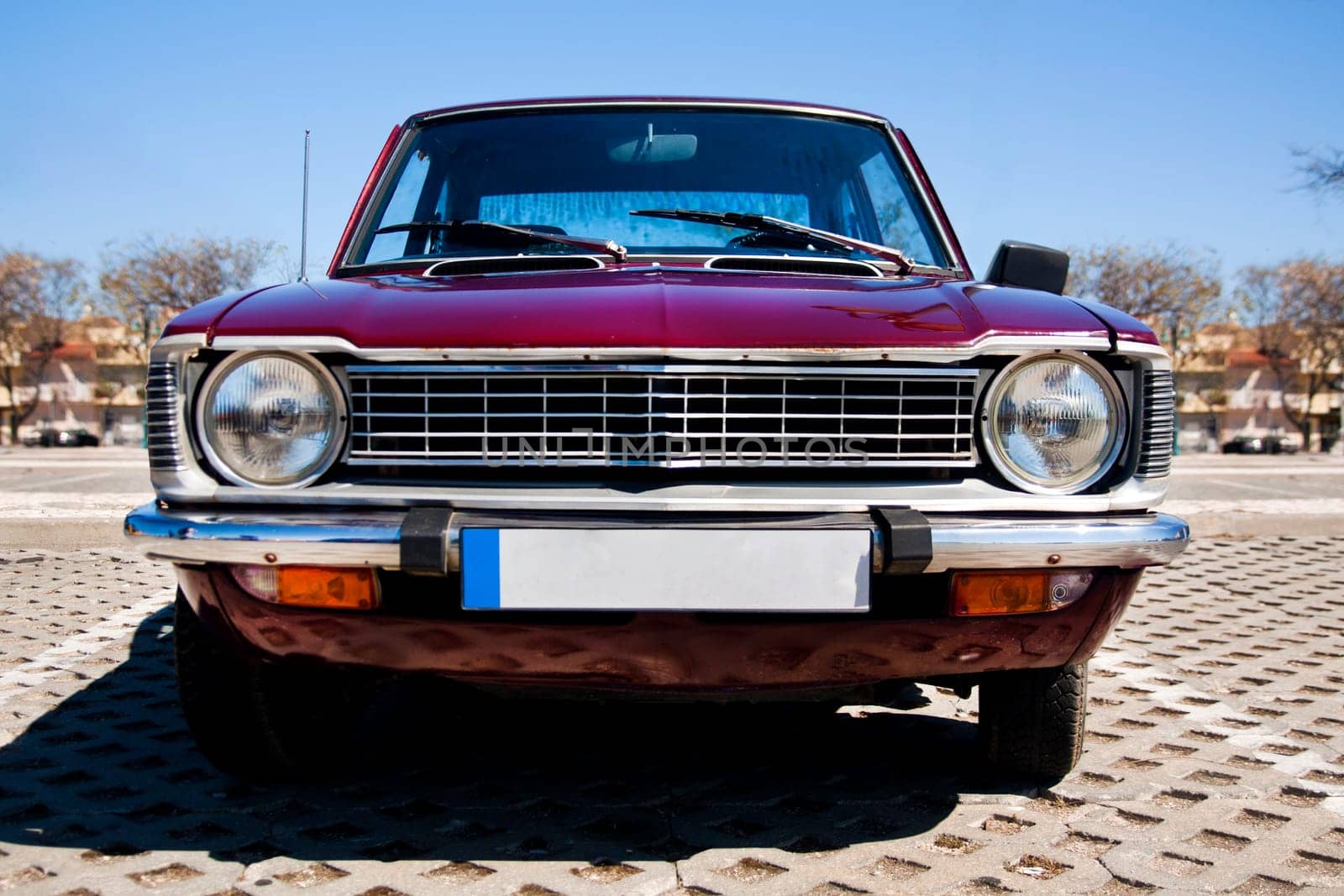 Close view of a classic car from the seventies parked on a park.