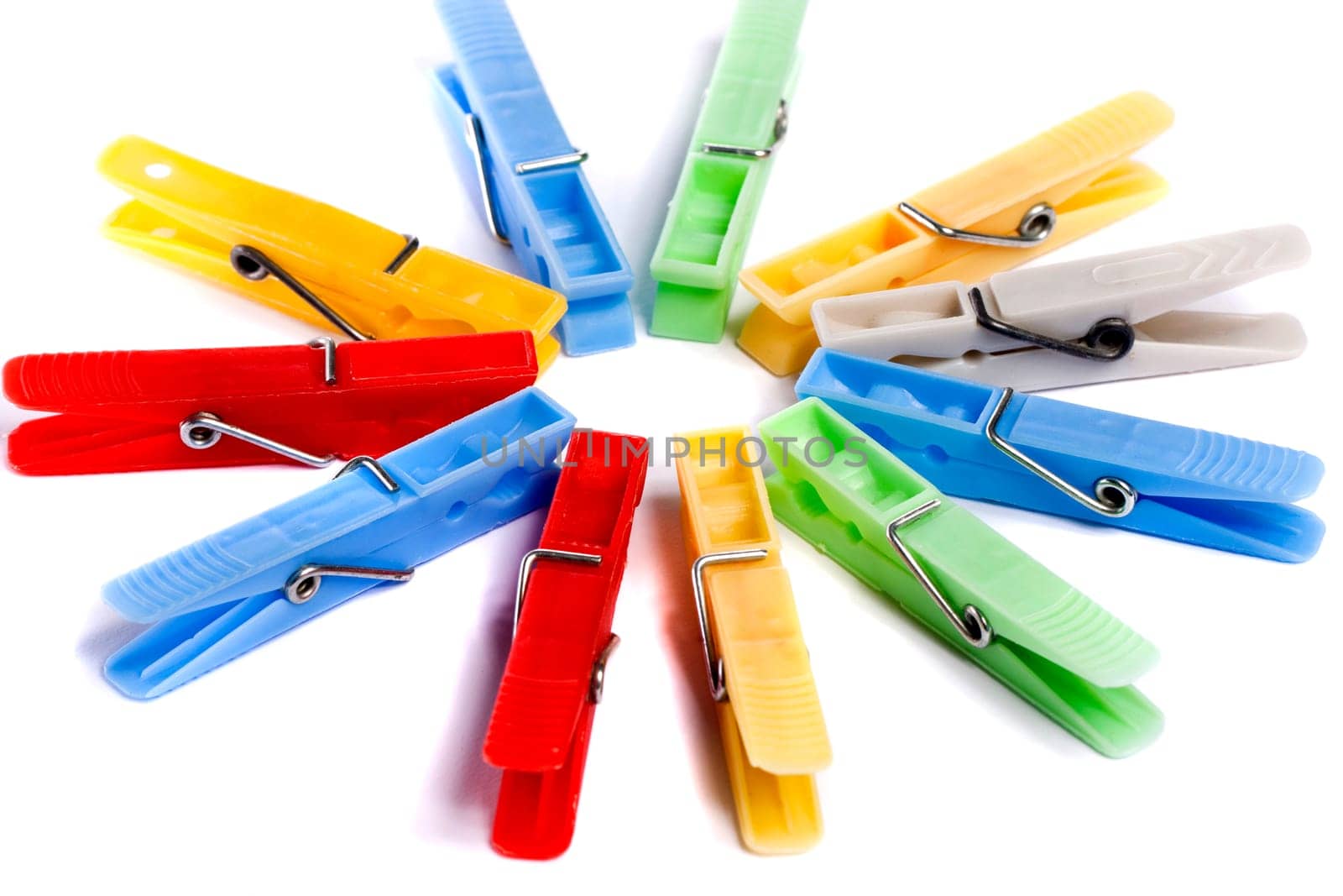 Close up view of some colorful cloth pegs isolated on a white background.