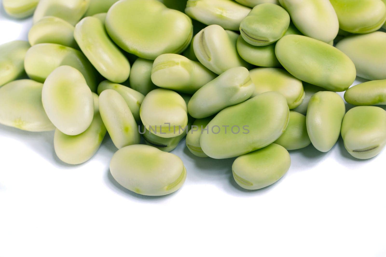 Close up view of some broad beans isolated on a white background.