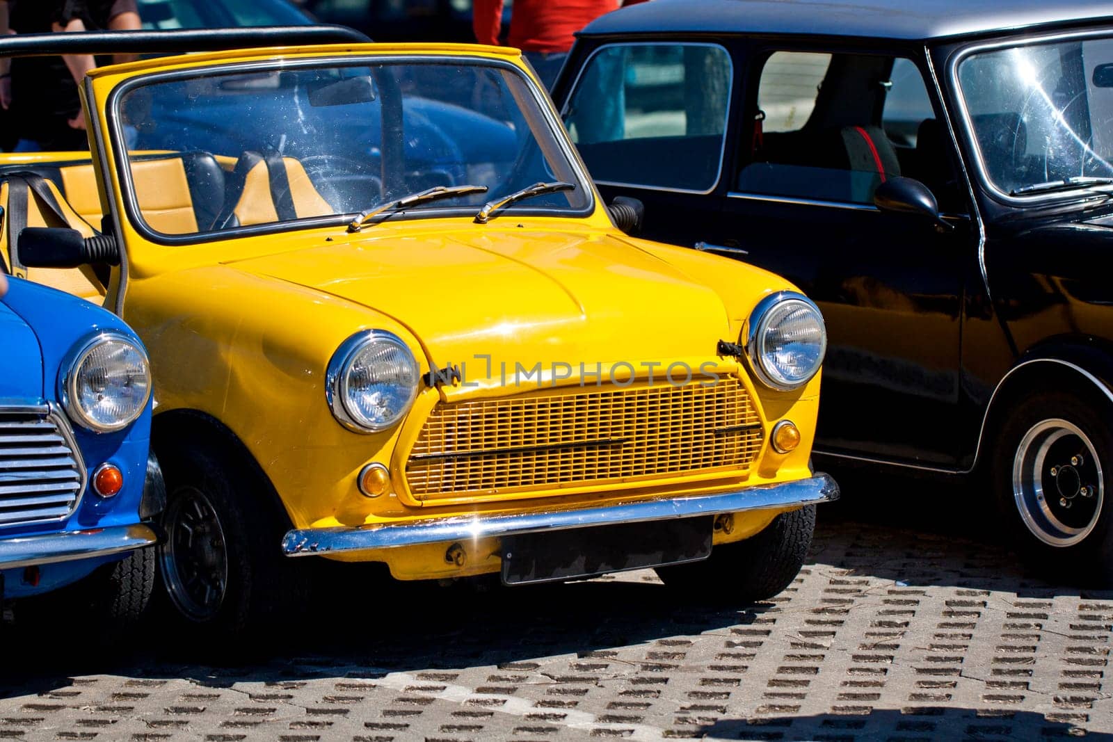 View of several mini classic cars aligned on a row.
