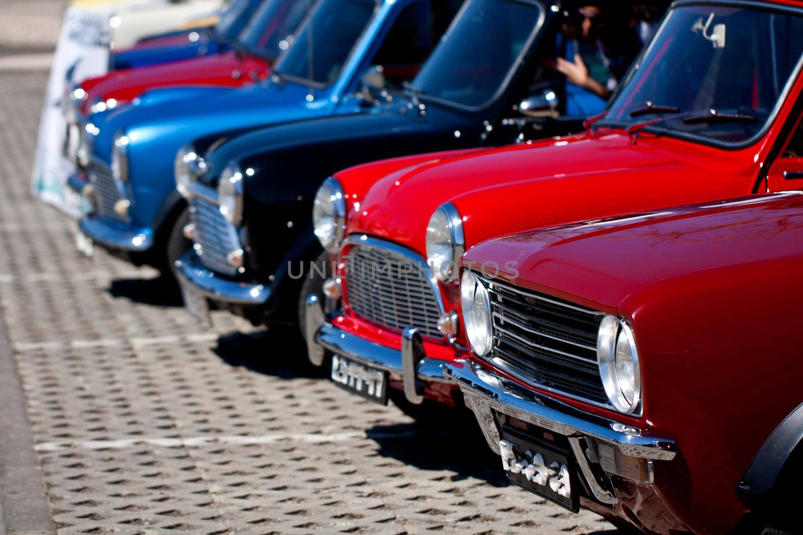 View of several mini classic cars aligned on a row.