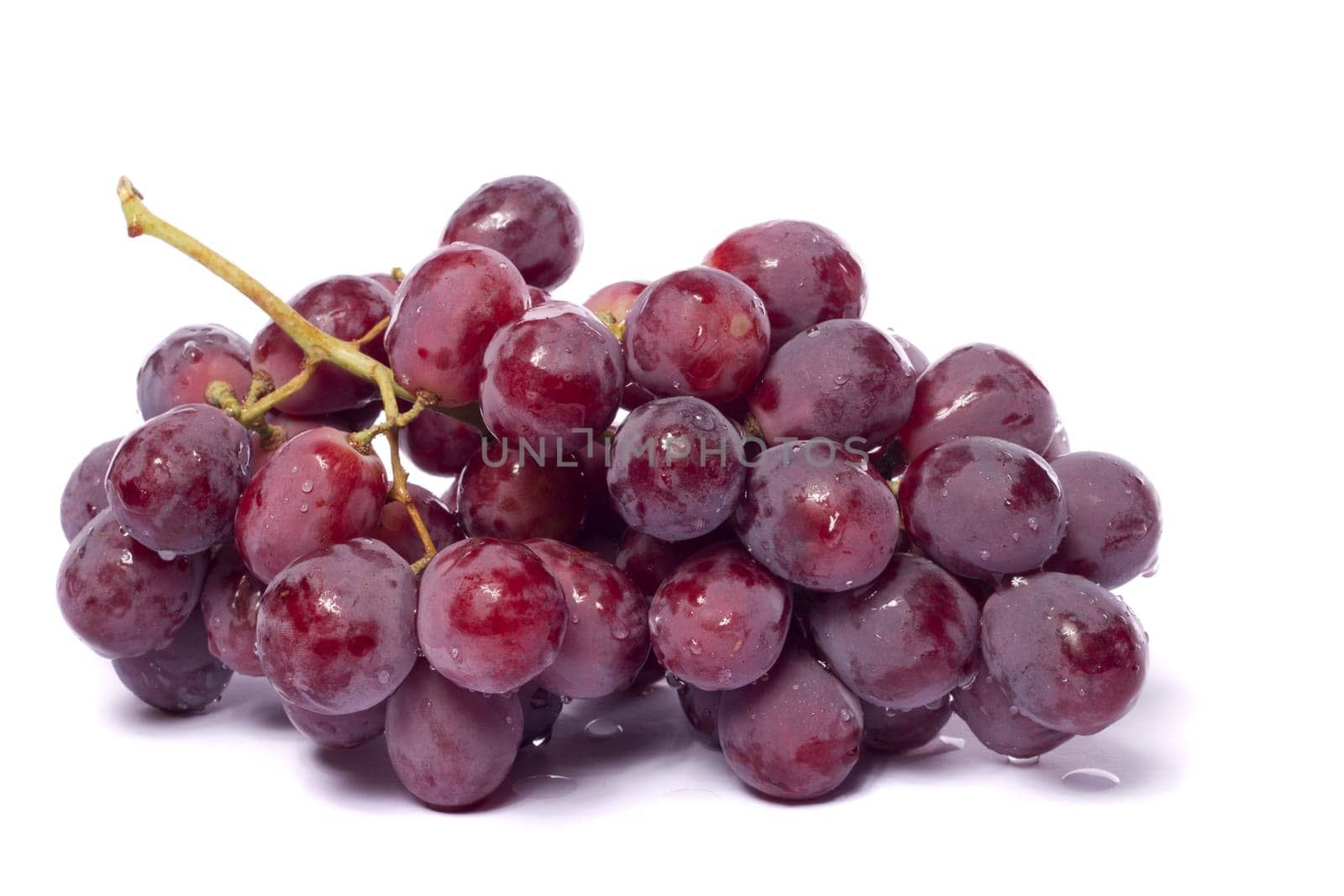 Close up view of some red wine grapes isolated on a white background.