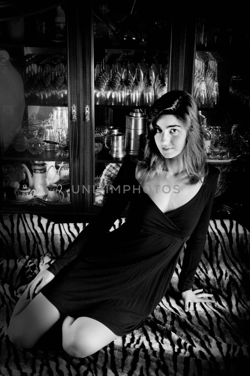 View of a beautiful young girl in a black dress on a living room.