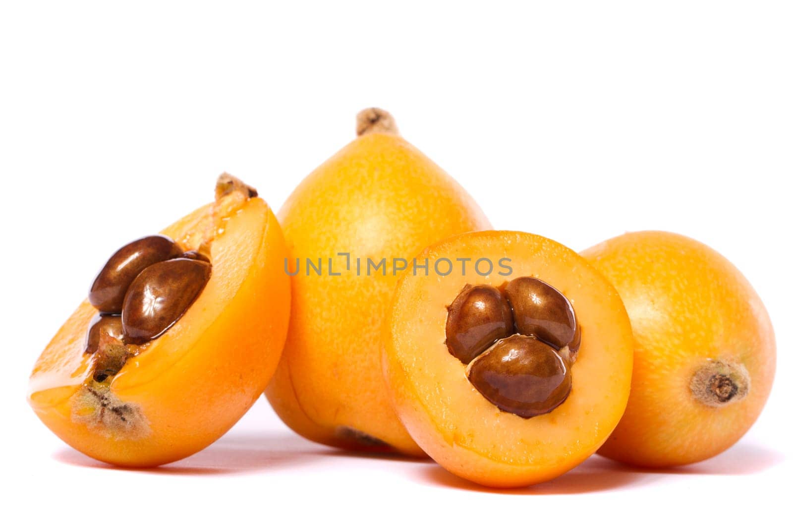 Close up view of some loquat fruit isolated on a white background.