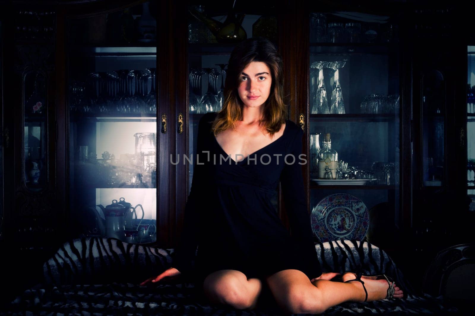 View of a beautiful young girl in a black dress on a living room.