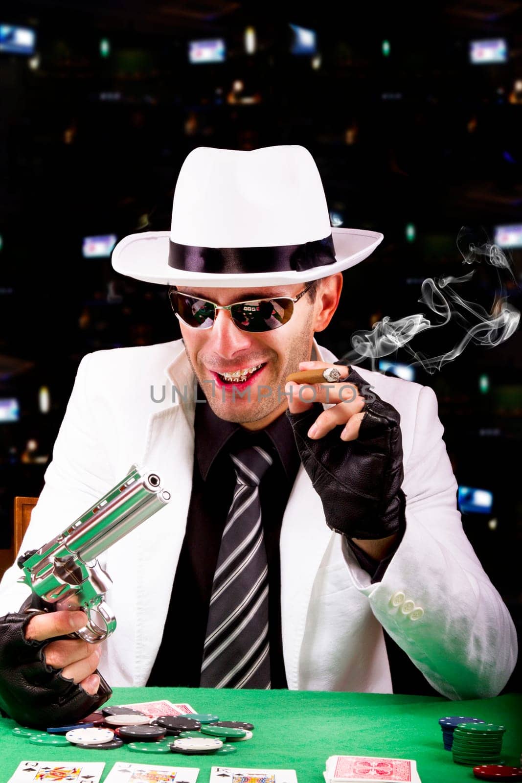 View of a gangster man playing some cards and poker, smoking a Cuban cigar.
