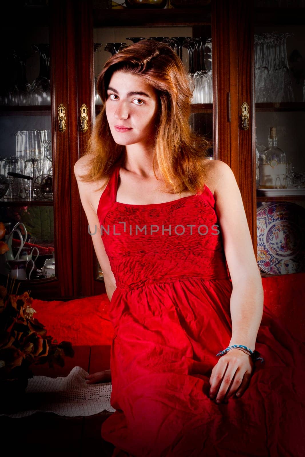 View of a beautiful young girl in a red dress on a living room.
