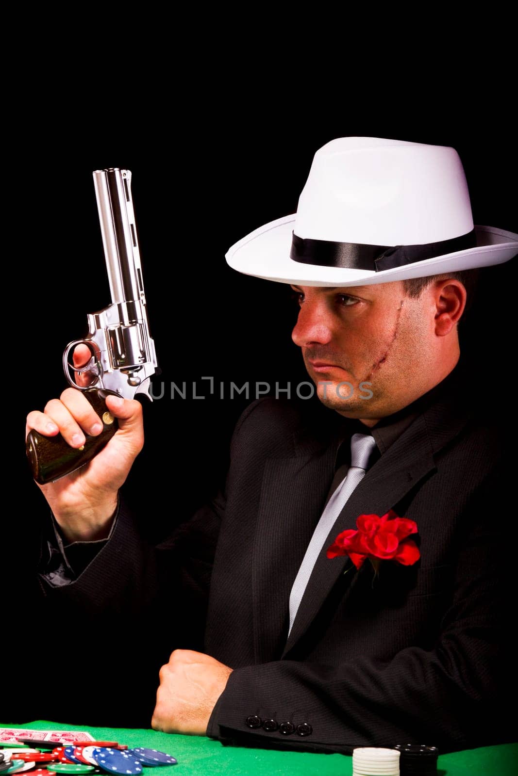 View of a dark suit gangster man holding a gun.