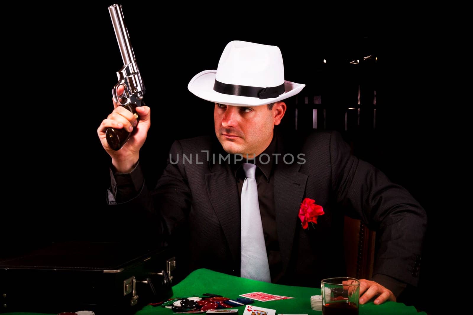 View of a dark suit gangster man holding a gun.