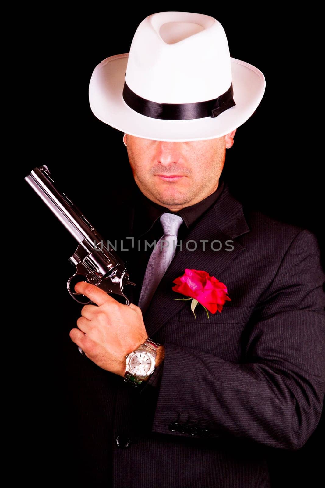 View of a dark suit gangster man holding a gun.