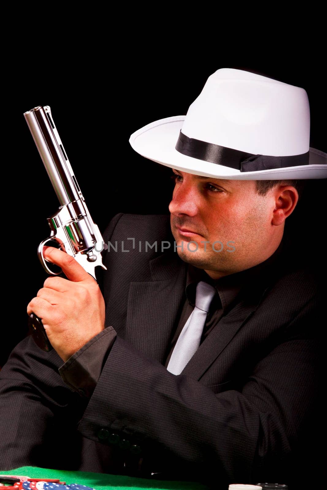 View of a dark suit gangster man holding a gun.