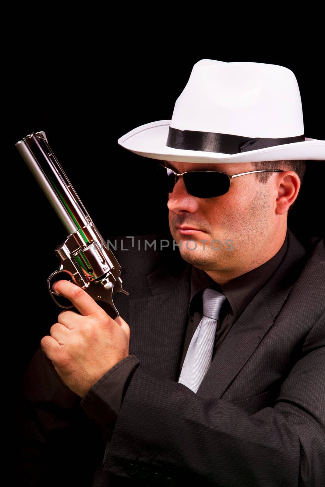 View of a dark suit gangster man holding a gun.