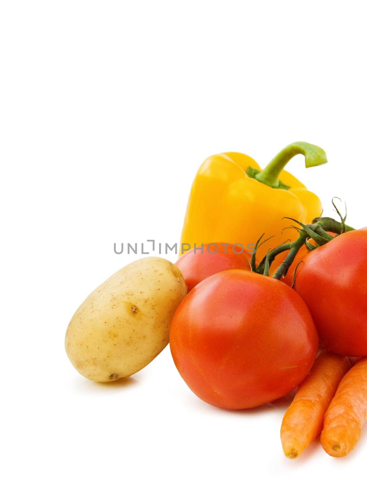 Healthy cooking with fresh vegetables - potato, tomatoes, carrots and peppers. Isolated over white.
