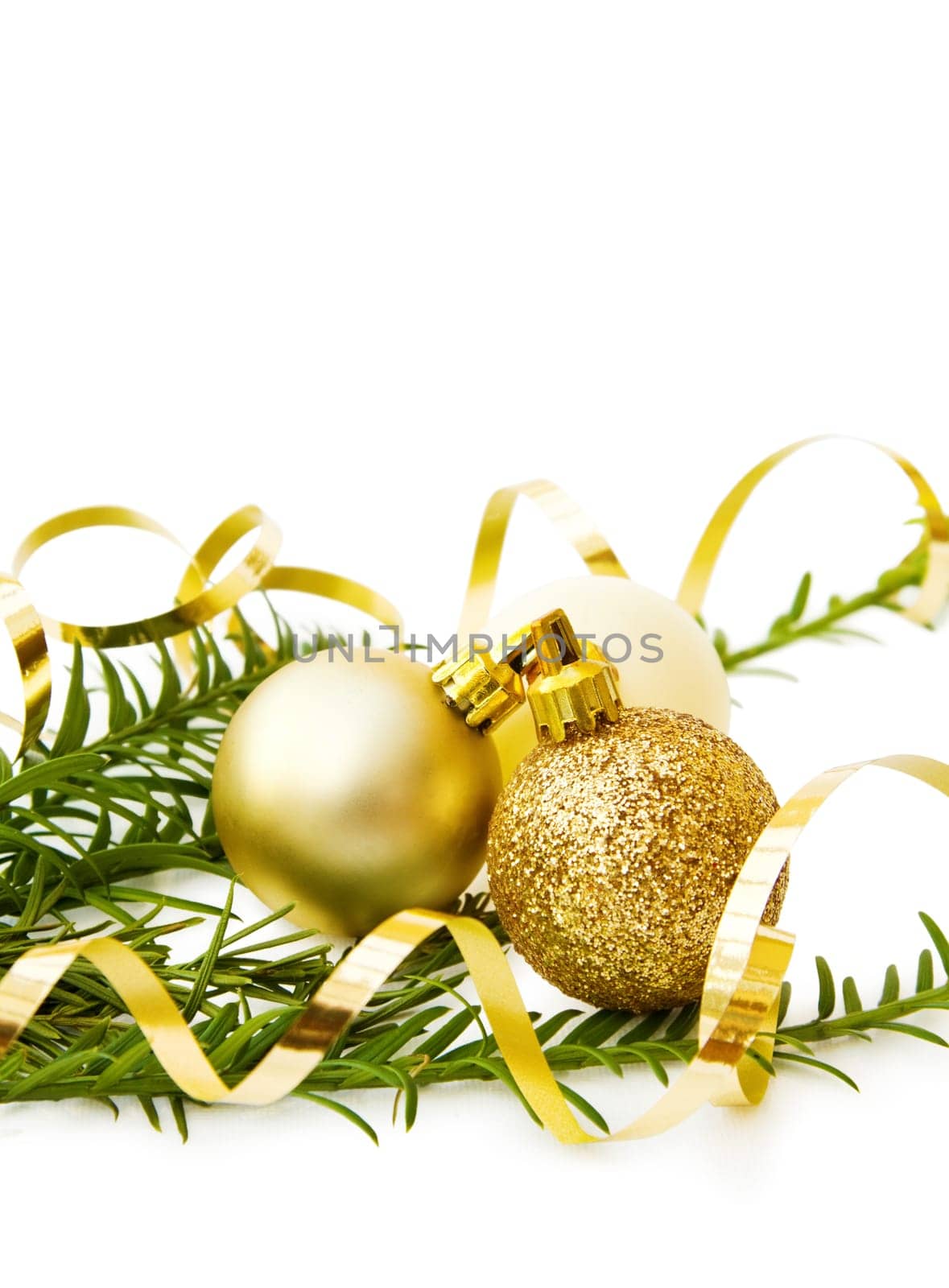 Celebrating Christmas with pine tree branch and golden baubles. Isolated on white background.