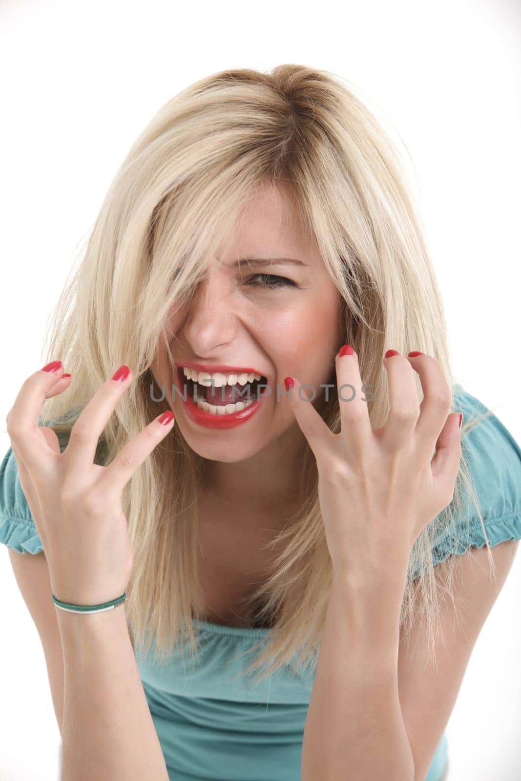 Angry young blond girl shouting with hands up.