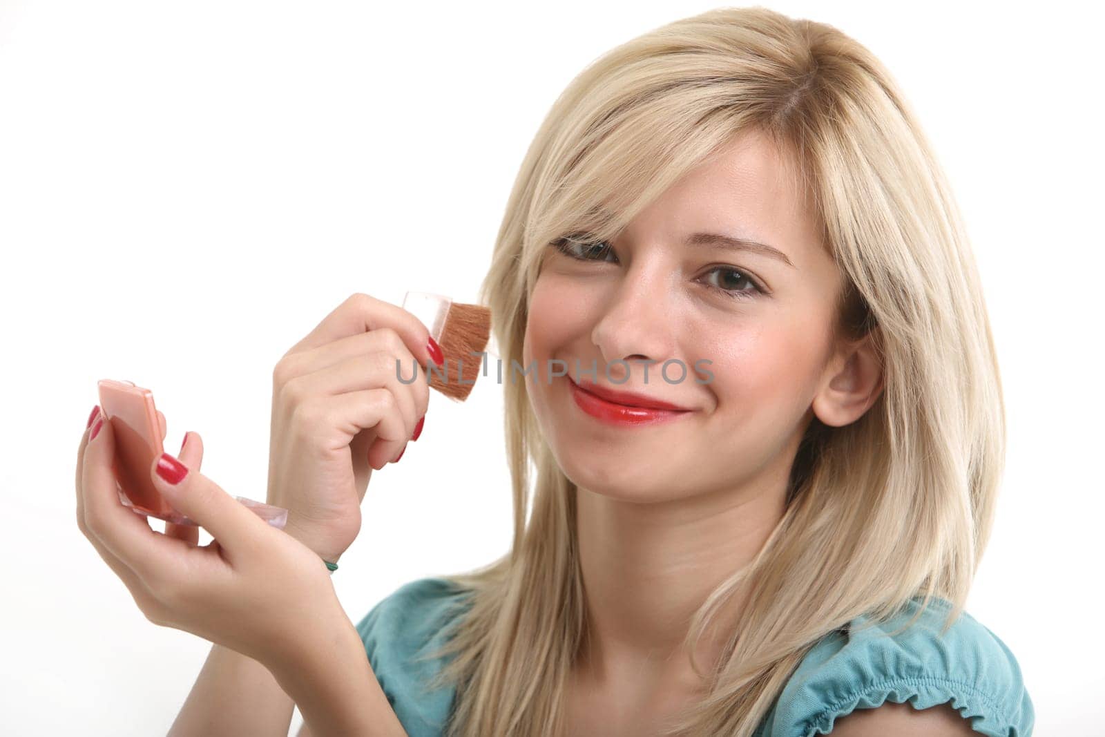 A young blonde doing make up with her small mirror.