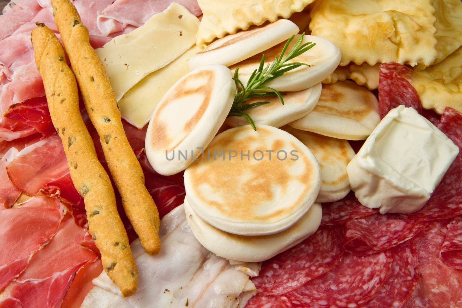 a platter of mixed cured meats, cheeses and fried dumpling